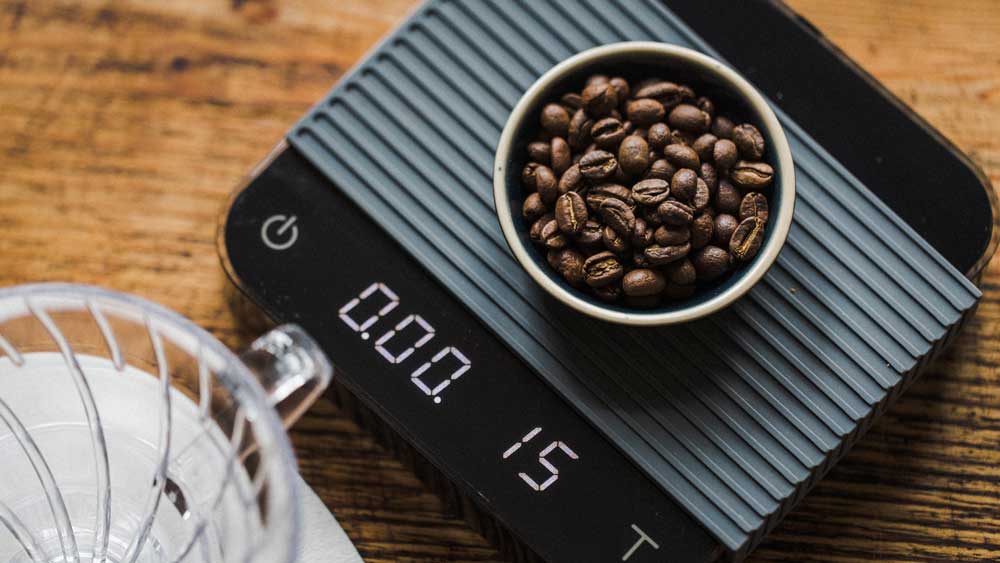 Coffee Beans Inside Shot Glass On Weight Scale With Empty Coffee