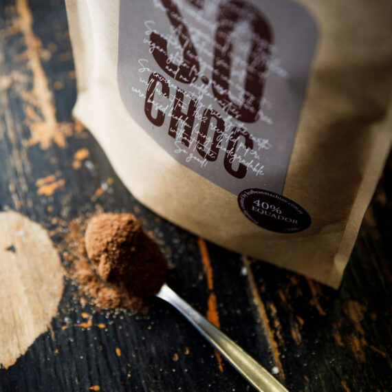 Single origin chocolate powder. Up close shot of the chocolate powder granules falling from a teaspoon onto a table.