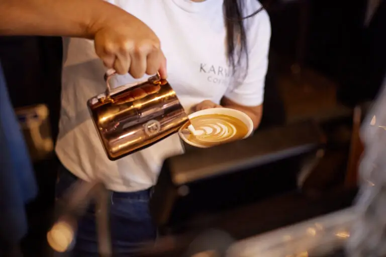 Milk being poured into espresso from a Barista milk jug.